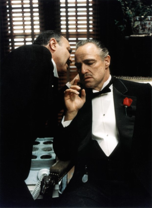 consigliere whispering somehting important to vito corleone